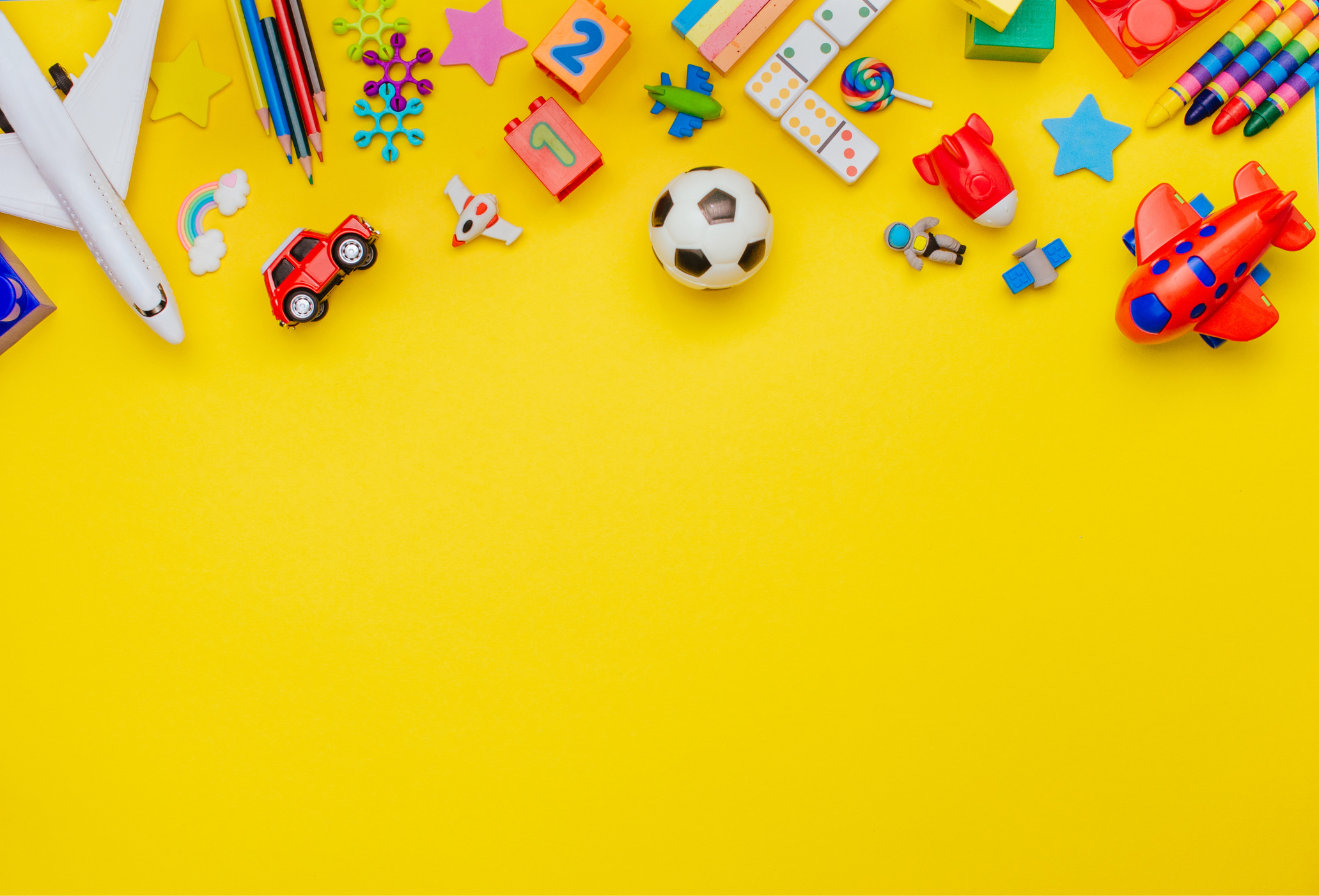 Frame of kids toys on yellow background